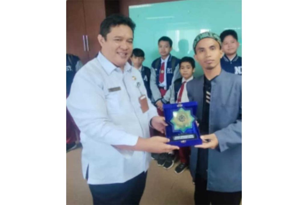 Christianus Benny Staf Ahli Gubernur Kaltim menerima plakat kenang-kenangan dari Ustadz Achmad Rasydinnur, direktur sekolah Luqman Al-Hakim Balikpapan.