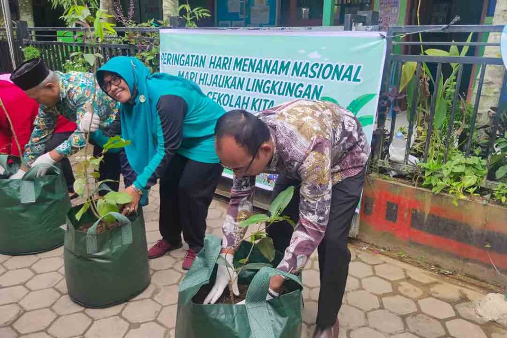 Nurkhayatun, S.Pd, Kepala SD Negeri 009 Samarinda Ilir (jilbab hijau) saat menanam tanaman untuk penghijauan sekolah.