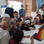 Para siswa SDIT Imam Syafi'i menyaksikan cara scan kartu anggota saat akan masuk perpustakaan