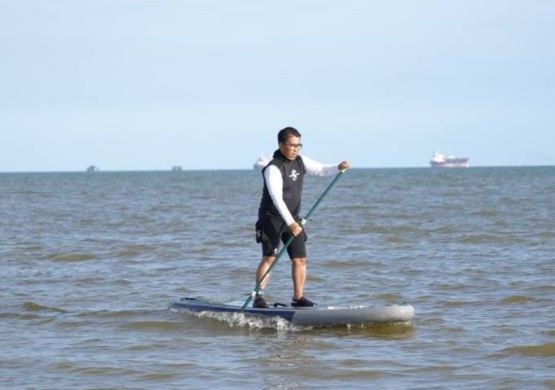 Akmal bermain paddling di Pantai Amal.