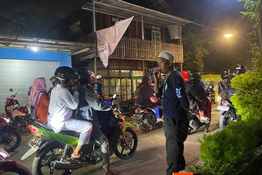 Relawan membantu mengatur lalu lintas